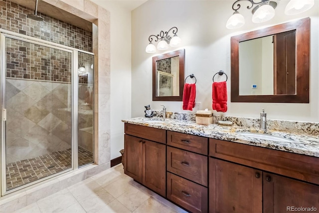 bathroom with double vanity, a stall shower, tile patterned flooring, and a sink