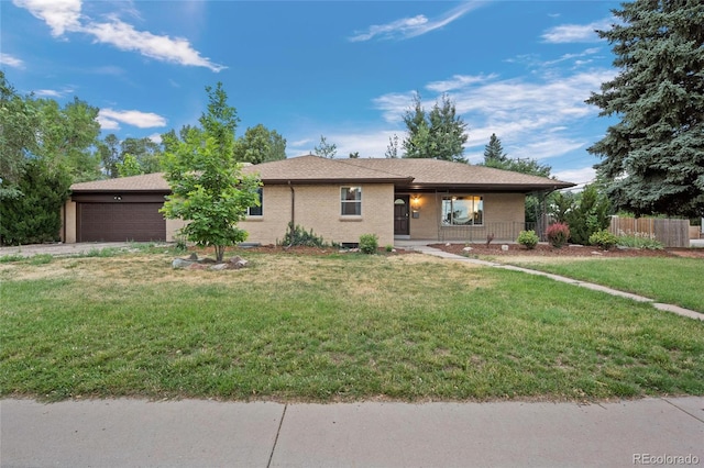 ranch-style home with a garage, a front yard, and covered porch