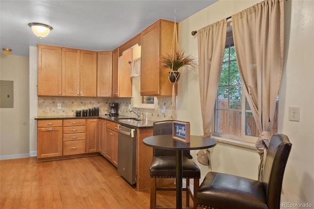 kitchen featuring tasteful backsplash, dishwasher, sink, and light hardwood / wood-style flooring