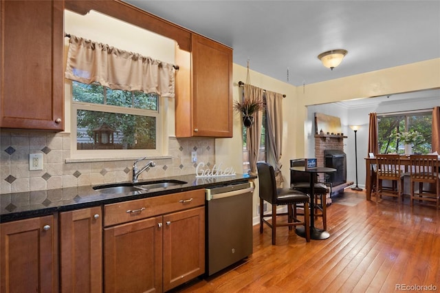 kitchen featuring tasteful backsplash, sink, stainless steel dishwasher, and dark stone counters