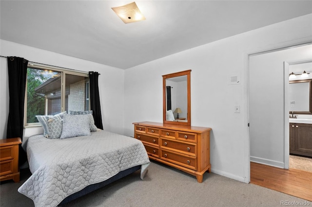 bedroom featuring sink, ensuite bath, and carpet flooring