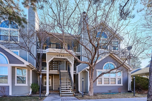 view of front facade with stairs, crawl space, and a balcony