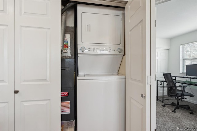 washroom featuring carpet floors, stacked washer and dryer, and laundry area