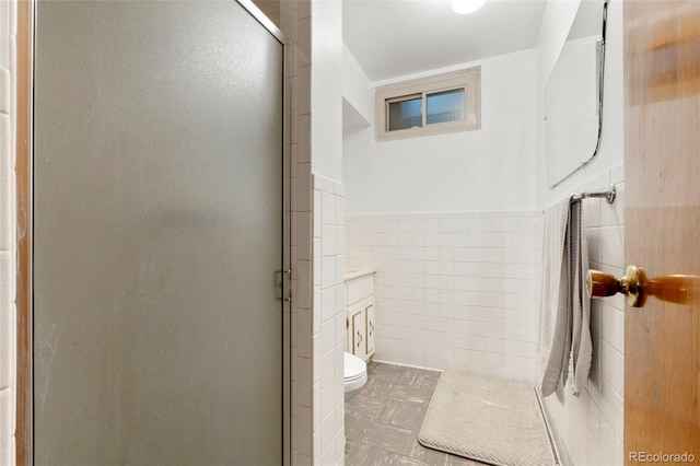 6981 Zuni St, Denver, CO 80221 - full bathroom with wainscoting, tile walls, toilet, and a shower stall