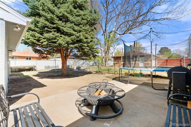 6981 Zuni St, Denver, CO 80221 - view of patio with a fenced backyard, a trampoline, and a fire pit