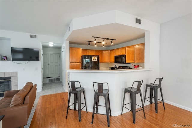 8707 E Florida Ave Unit 510, Denver, CO 80247 - kitchen with visible vents, black appliances, and a breakfast bar