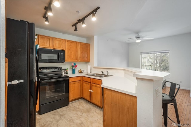 8707 E Florida Ave Unit 510, Denver, CO 80247 - kitchen featuring ceiling fan, a sink, light countertops, black appliances, and a peninsula