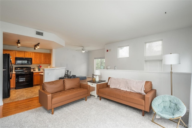 8707 E Florida Ave Unit 510, Denver, CO 80247 - living room featuring visible vents, a ceiling fan, and light carpet