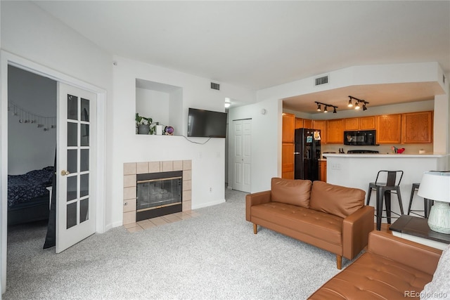 8707 E Florida Ave Unit 510, Denver, CO 80247 - living area featuring visible vents, track lighting, light carpet, and a tile fireplace