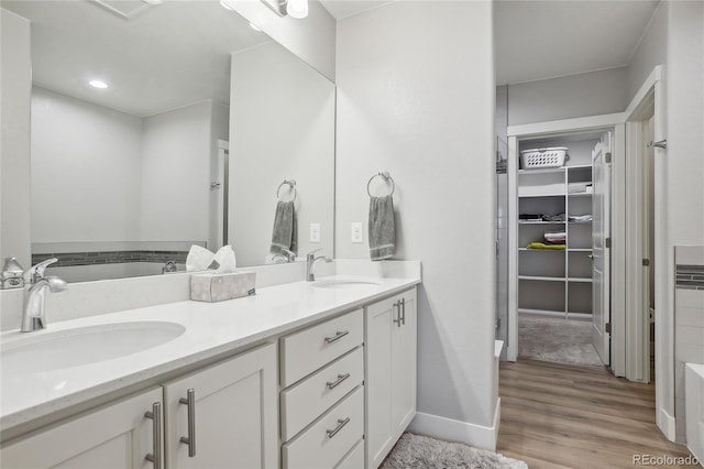 bathroom featuring hardwood / wood-style floors, a tub to relax in, and vanity