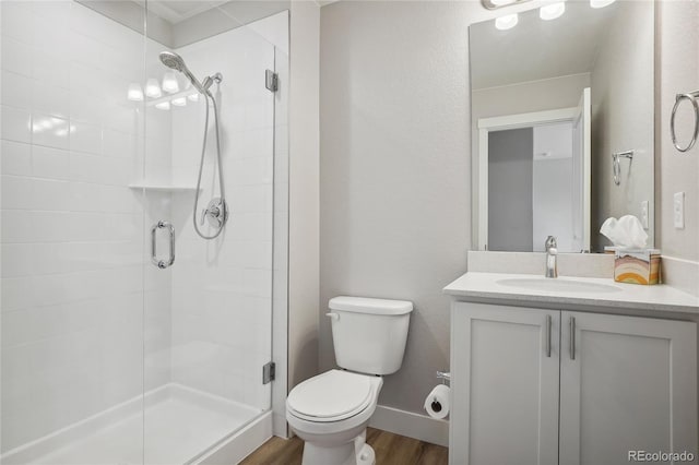 bathroom with vanity, toilet, walk in shower, and wood-type flooring