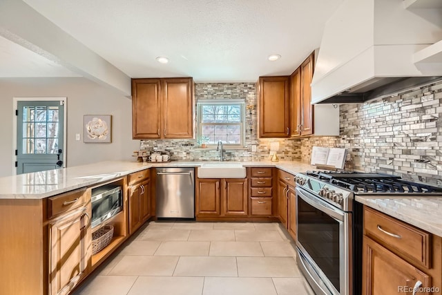 kitchen featuring premium range hood, appliances with stainless steel finishes, sink, decorative backsplash, and kitchen peninsula