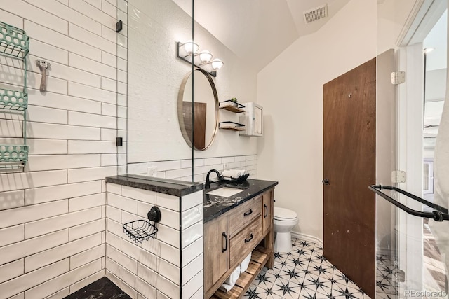 bathroom with lofted ceiling, vanity, and toilet