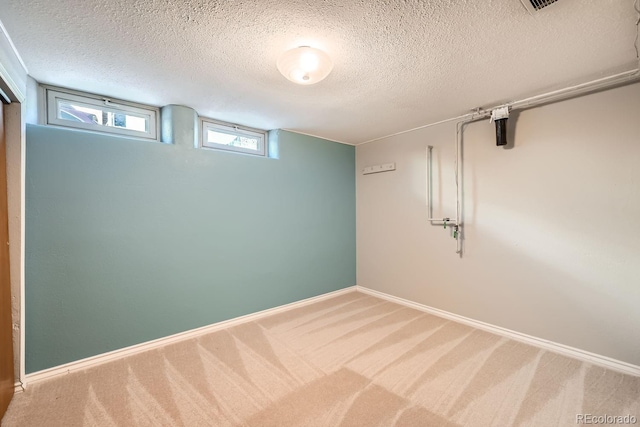 basement featuring a textured ceiling and carpet flooring