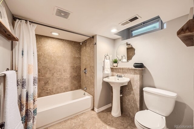 bathroom with shower / bath combination with curtain and toilet