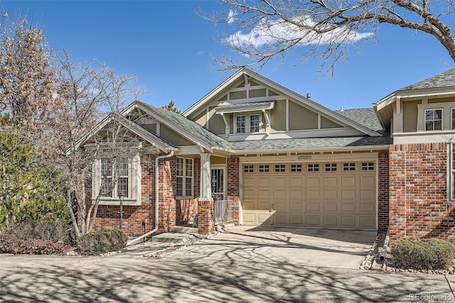 view of front of home featuring a garage, a shingled roof, concrete driveway, and brick siding