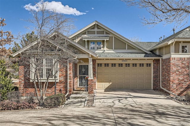 view of front facade featuring a shingled roof, concrete driveway, and brick siding