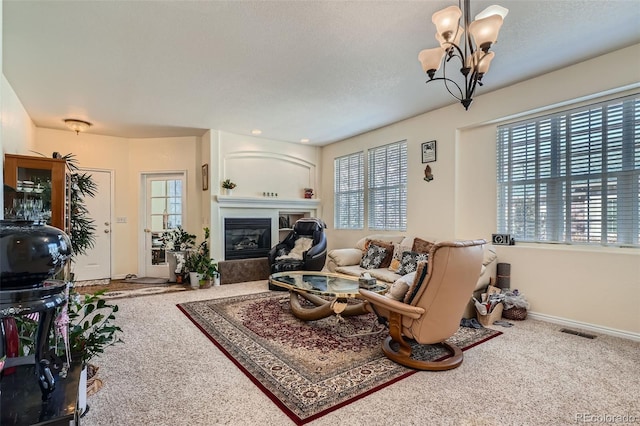 carpeted living room featuring a glass covered fireplace, a healthy amount of sunlight, visible vents, and baseboards