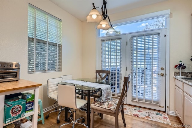 dining area with light wood-style flooring and baseboards