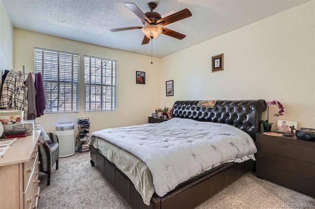 bedroom with light carpet, a textured ceiling, and a ceiling fan