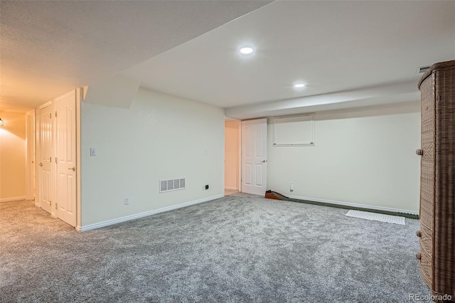 finished below grade area featuring carpet, visible vents, baseboards, and recessed lighting