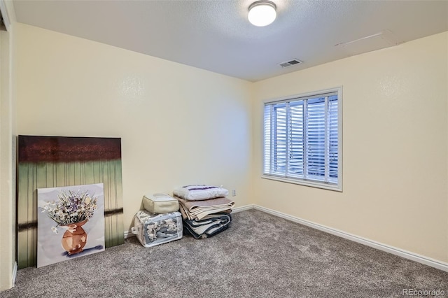 interior space featuring carpet floors, baseboards, visible vents, and a textured ceiling