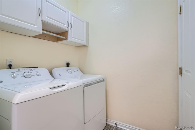 washroom featuring cabinet space, baseboards, and washer and dryer