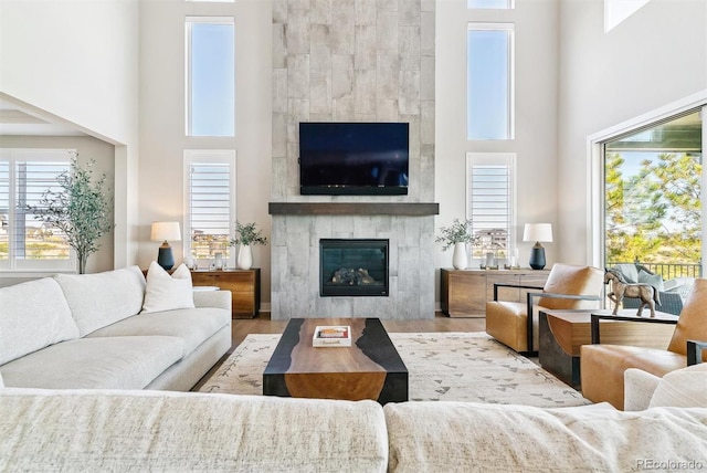 living room featuring hardwood / wood-style floors, a fireplace, and a high ceiling