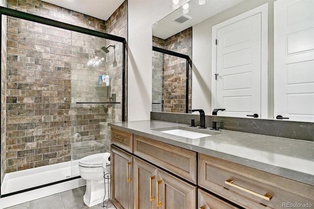 bathroom featuring vanity, a shower with shower door, and toilet