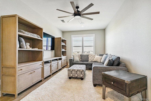 living room with ceiling fan and light hardwood / wood-style flooring