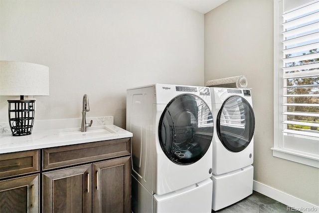 laundry room with cabinets, washing machine and dryer, and sink