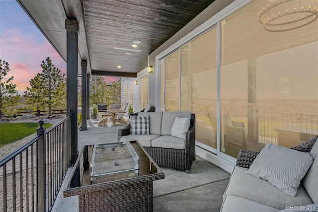 patio terrace at dusk with an outdoor hangout area and a balcony