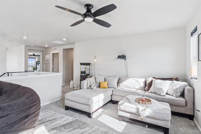 living area featuring light carpet, visible vents, a ceiling fan, and baseboards