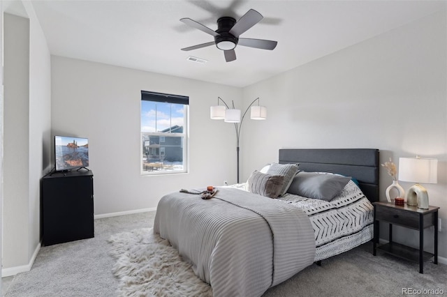 bedroom featuring light carpet, baseboards, visible vents, and a ceiling fan