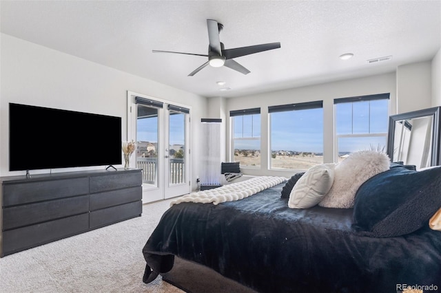 carpeted bedroom with access to exterior, ceiling fan, visible vents, and a textured ceiling