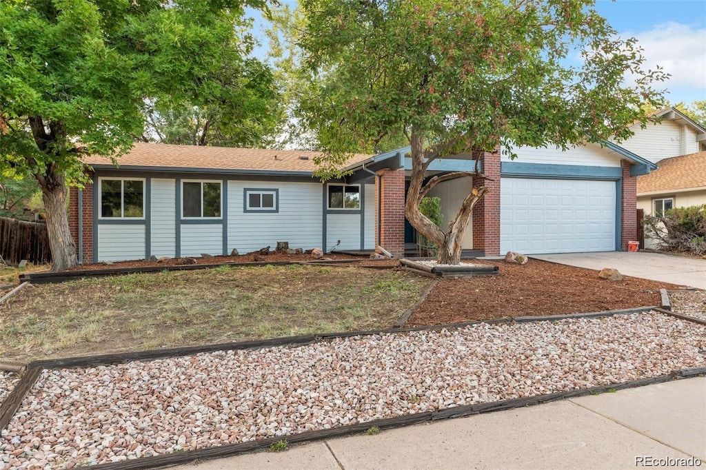 ranch-style house with a garage, driveway, and brick siding