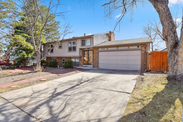 view of front of house with fence, a chimney, concrete driveway, a garage, and brick siding