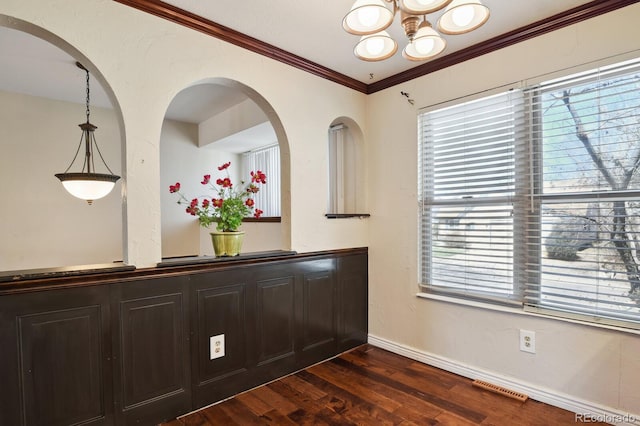 interior space featuring visible vents, wood finished floors, an inviting chandelier, crown molding, and baseboards