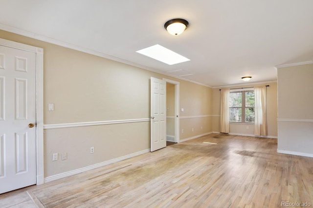 spare room featuring baseboards, wood finished floors, and ornamental molding