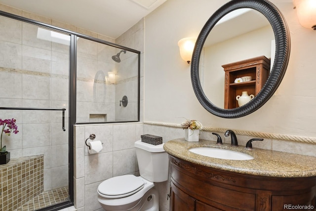 full bathroom with vanity, tile walls, toilet, and a stall shower