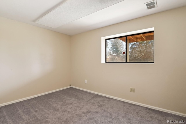 carpeted spare room with baseboards and visible vents