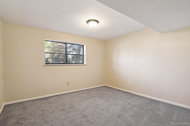 spare room featuring baseboards and carpet floors