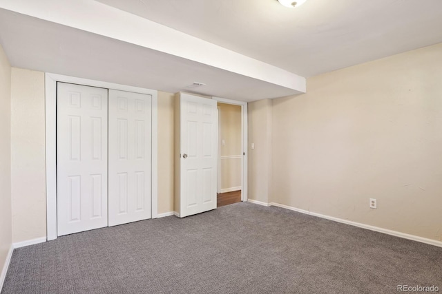 unfurnished bedroom with carpet flooring, baseboards, and a closet