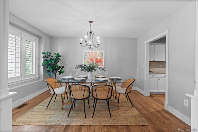 1366 S Vine St, Denver, CO 80210 - dining space with wood finished floors, a chandelier, and baseboards