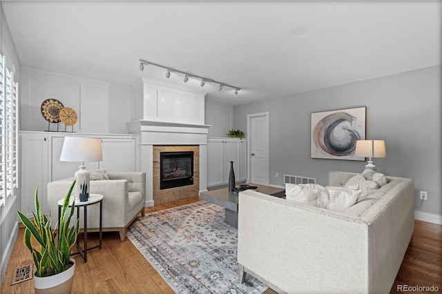 1366 S Vine St, Denver, CO 80210 - living area with wood finished floors, a tiled fireplace, and rail lighting