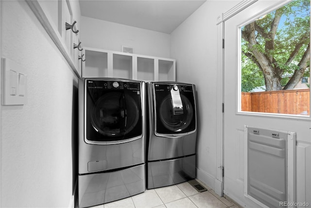 1366 S Vine St, Denver, CO 80210 - washroom with washing machine and clothes dryer, healthy amount of natural light, light tile patterned floors, and baseboards