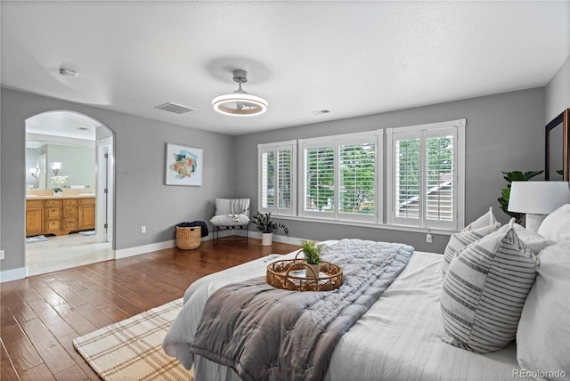 1366 S Vine St, Denver, CO 80210 - bedroom with arched walkways, wood finished floors, and ensuite bath