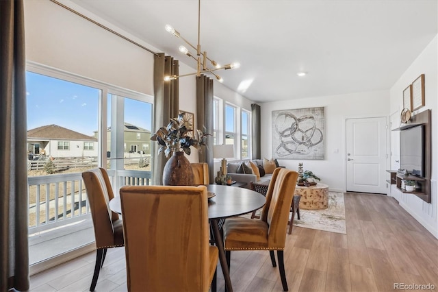 dining space with an inviting chandelier and light hardwood / wood-style floors