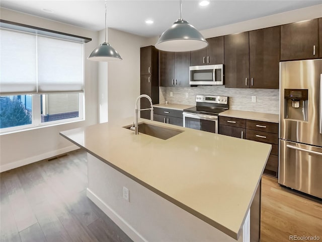 11267 Central Ct, Broomfield, CO 80021 - kitchen with appliances with stainless steel finishes, light countertops, tasteful backsplash, light wood-style floors, and recessed lighting