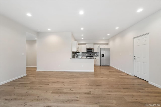 875 E 78th Ave Unit 52, Denver, CO 80229 - kitchen with appliances with stainless steel finishes, white cabinets, recessed lighting, baseboards, and tasteful backsplash